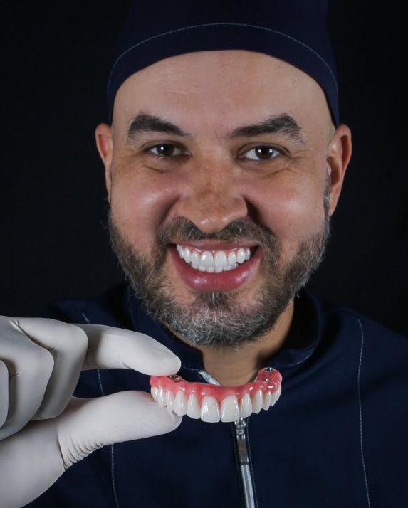 Dr. Bruno Franciel — Cirurgião-dentista, segurando prótese sobre implante